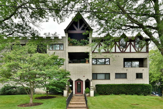 Front view of a multi-story residential building with decorative facade and balconies.