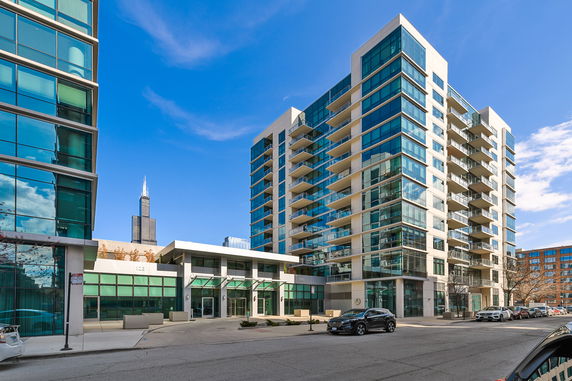 Front view of a multi-story building with glass balconies and large windows.