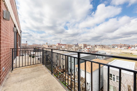 View from a building balcony showing surrounding rooftops and urban skyline.
