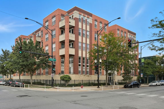 Front view of a multi-story apartment building with red brick exterior.