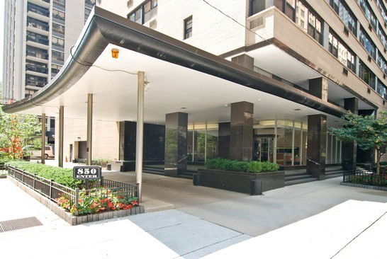 Front view of a modern multi-story building with an overhanging canopy.