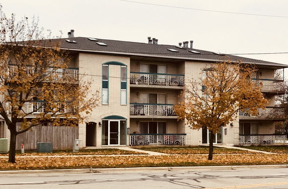 Front view of a multi-story apartment building with balconies.