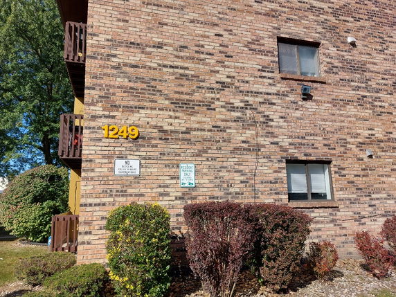 Side view of a brick building with two small windows and balconies.