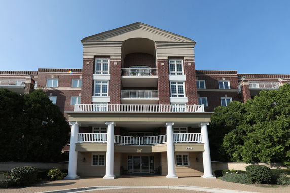 Front view of a multi-story building with brick facade and white columns.