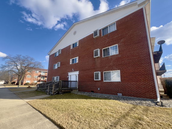 Front view of a brick multi-story apartment building.