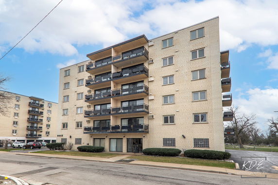 Front view of a multi-story apartment building with balconies.