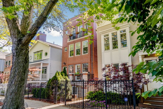 Front view of a row of multi-story houses with different facade designs.