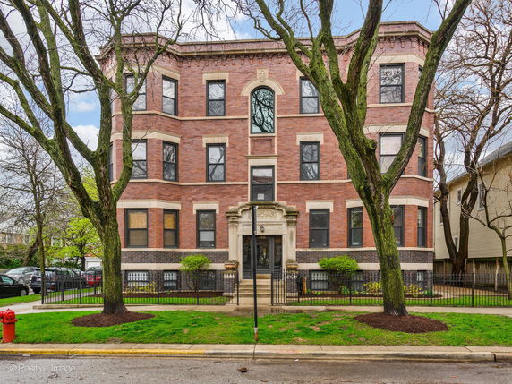 Front view of a three-story brick building with multiple windows and an entrance.