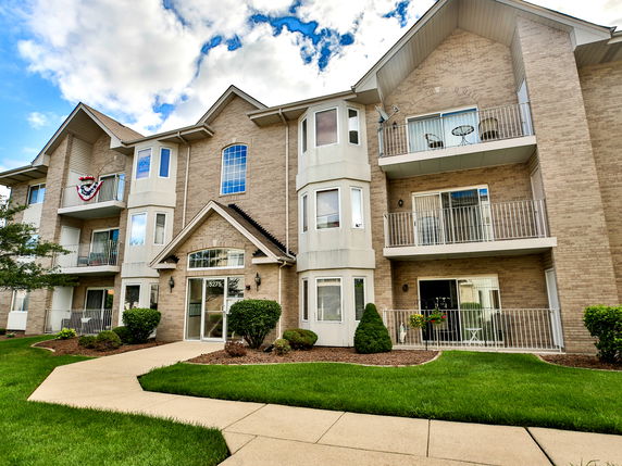 Front view of a multi-story building with balconies and large windows.