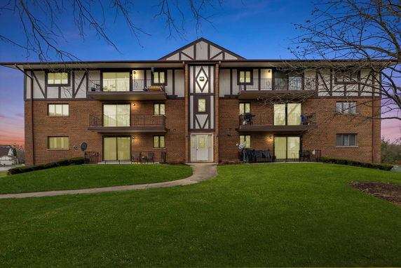 Front view of a multi-story building with balconies and a Tudor-style design.