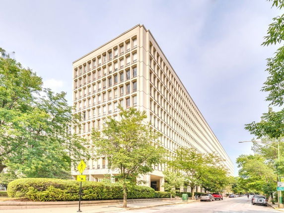 Front view of a multi-story office building with large windows.