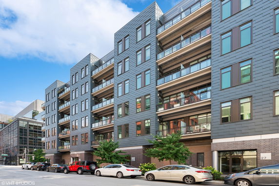 Front view of a modern multi-story apartment building with balconies.