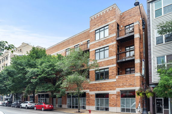 Front view of a multi-story brick building with balconies.