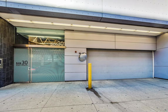 Front view of a modern building entrance with a garage door.