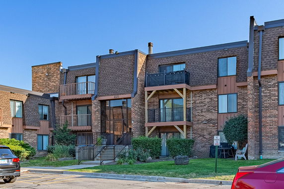 Front view of a three-story apartment building with balconies.