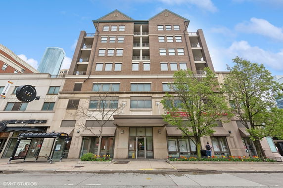 Front view of a multi-story building with a ground floor entrance and balconies.