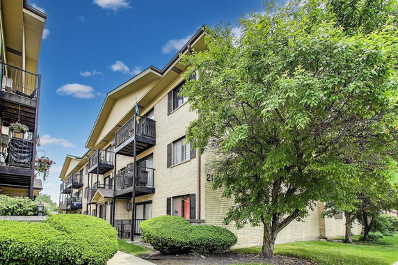 Front view of a multi-story apartment building with balconies.