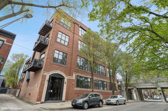 Front view of a multi-story brick building with balconies.