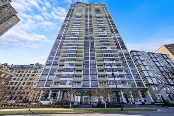 Front view of a tall residential building with many balconies.
