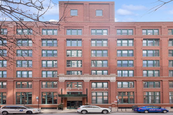 Front view of a multi-story brick building with numerous windows.