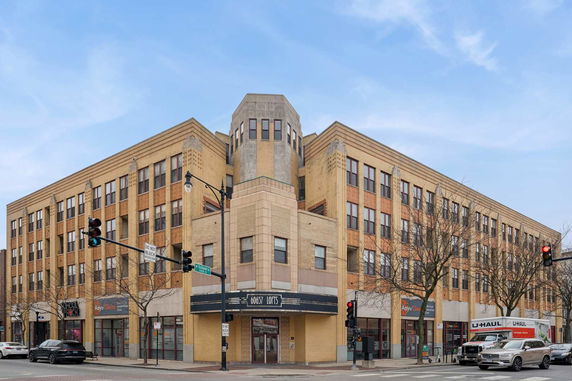 Front view of a multi-story building with a unique corner tower design.