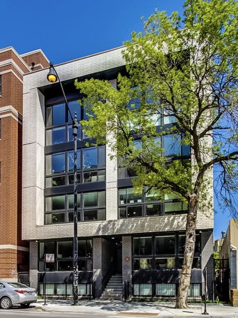 Front view of a modern multi-story building with large windows.