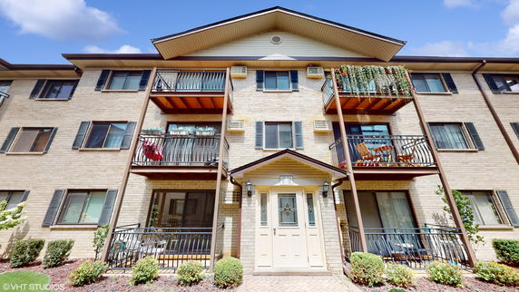 Front view of a multi-story apartment building with balconies.