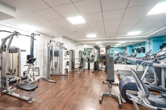 Gym area with various exercise machines and equipment.