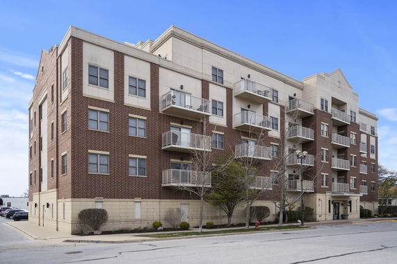 Front view of a multi-story apartment building with balconies.