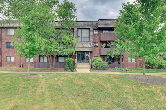 Front view of a multi-story brick building with balconies.