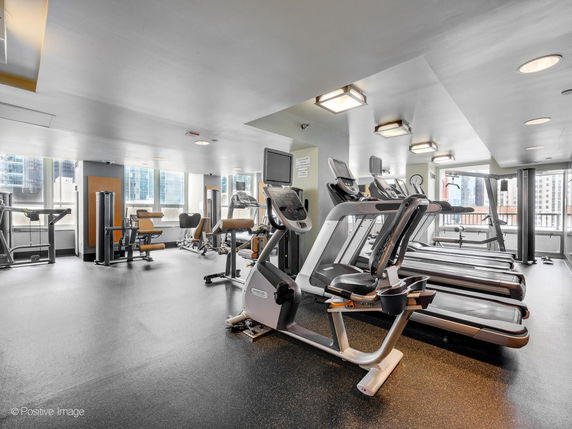 Indoor gym area with various exercise machines and treadmills.
