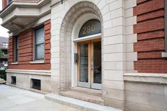 Front view of a building with red brickwork and arched entrance.