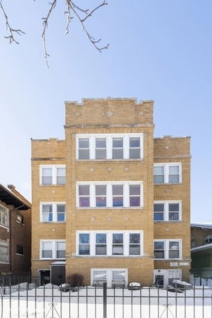 Front view of a multi-story brick building with multiple windows.