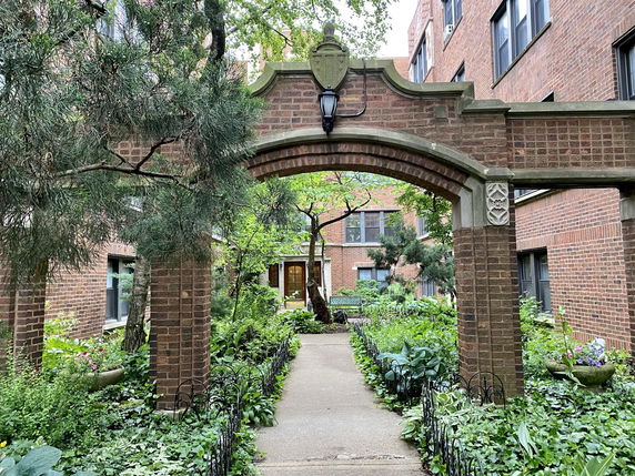 Outdoor view with an archway and brick buildings.
