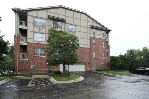 Front view of a multi-story residential building with brick exterior and balconies.
