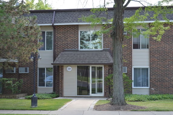 Front view of a two-story building with brick facade and multiple windows.