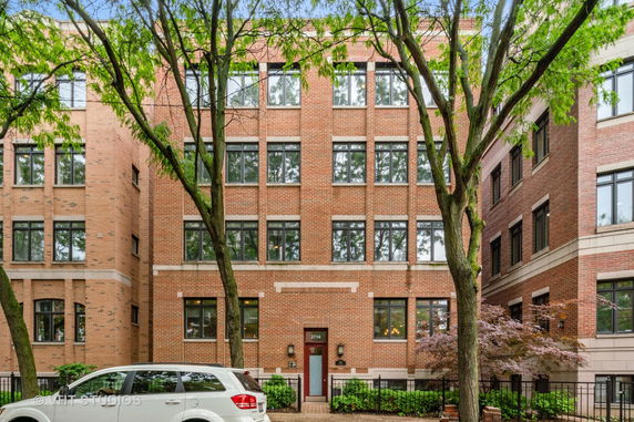 Front view of a multi-story brick building with large windows.