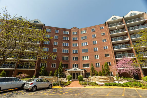 Front view of a multi-story brick apartment building with balconies.