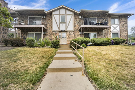 Front view of a two-story apartment building with balconies.