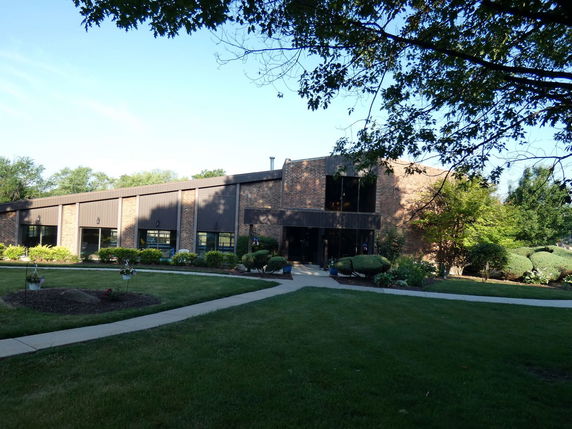 Front view of a single-story building with large windows and brick facade.