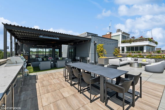 Modern rooftop terrace with outdoor seating, dining area, and pergola.