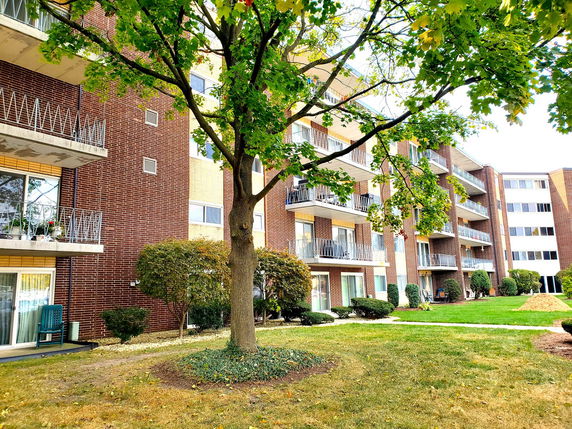 Front view of a multi-story apartment building with balconies.