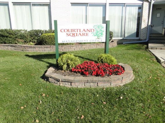 Front view of a building with a management office sign and landscaping.