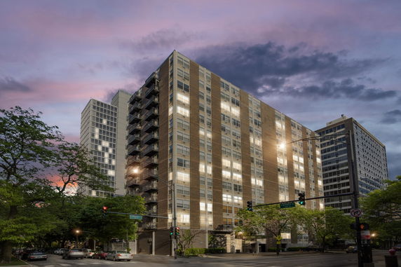 Front view of a multi-story apartment building at dusk.