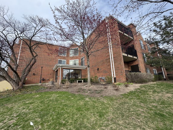 Front view of a multi-story brick building with balconies.