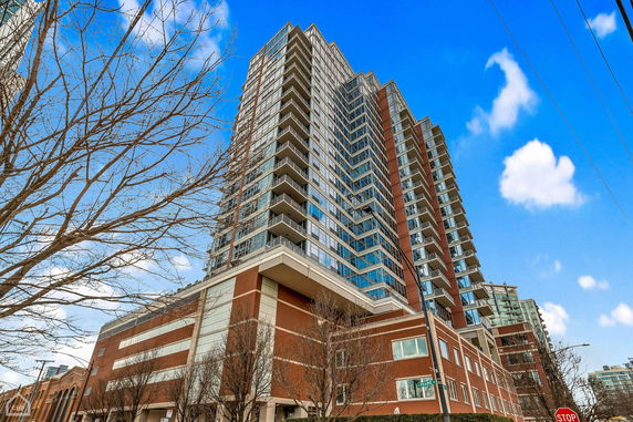 Front view of a high-rise residential building with multiple balconies and large windows.