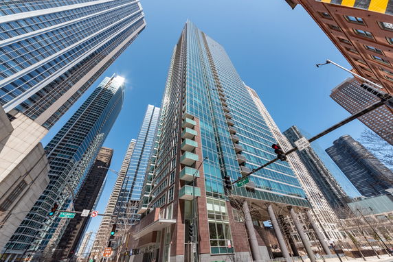 Front view of a modern high-rise building with glass facade in an urban setting.