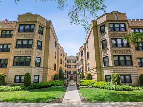 Front view of a large multi-story apartment building with decorative stonework.