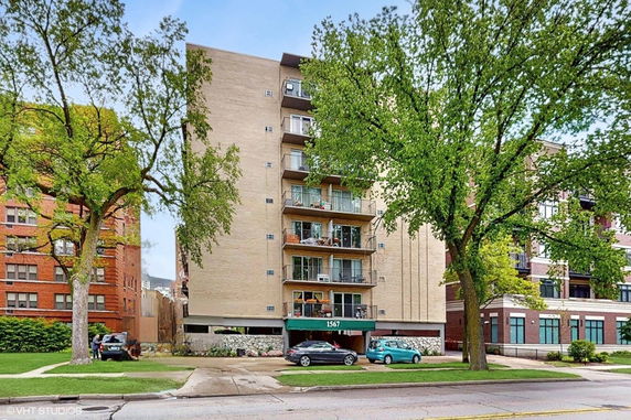 Front view of a multi-story apartment building with balconies.