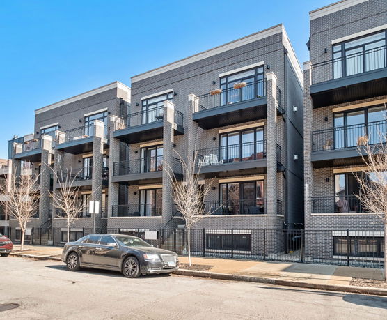 Front view of a multi-story modern apartment building with brick exterior.
